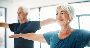 Couple practicing yoga at a gym