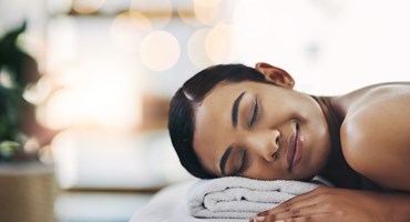 ChooseHealthy™ Closeup of womans' smiling face in spa, relaxing on spa table