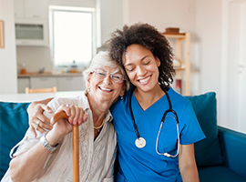 Nurse side hugging senior woman