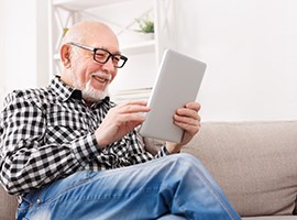 Prevention And Education Smiling senior looking at iPad