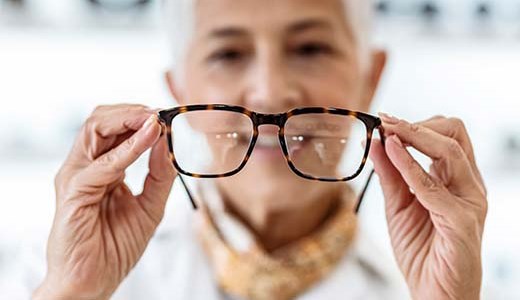 mujer sosteniendo unos anteojos