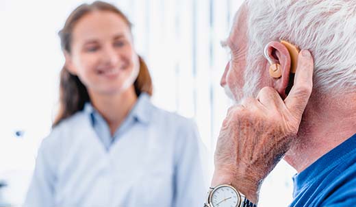 Older man getting fitted for a hearing aid