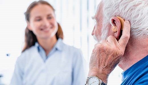 Older man getting fitted for a hearing aid