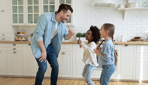 Father in kitchen with young daughter and friend