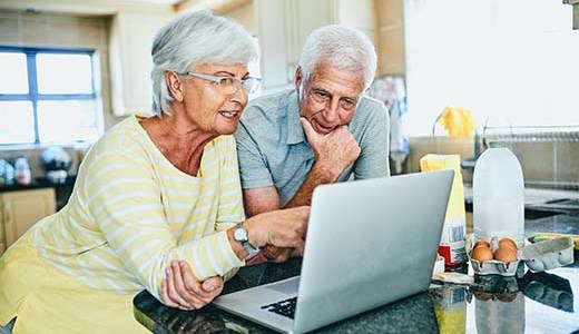 Pareja de adultos mayores mirando una computadora