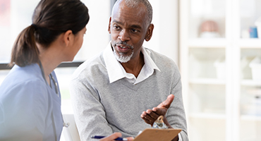 patient and case manager talking about conditions, laptop on desk