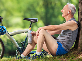 Hombre mayor descansando junto a una bicicleta
