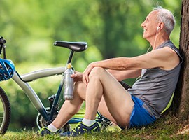Programs And Tools Senior man resting by a bike