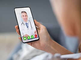 Primer plano de un médico en una sesión de consulta virtual a través del teléfono celular