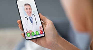 Find a Doctor Or Facility Close up of doctor on virtual visit cell phone session