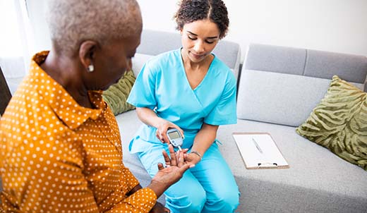Nurse checking blood sugar levels on a senior woman