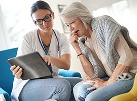 Un proveedor le muestra su laptop a un paciente