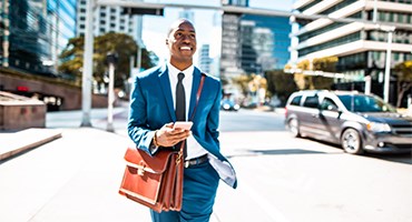 Business man with briefcase walking down urban street