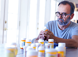 Man reading Rx bottles