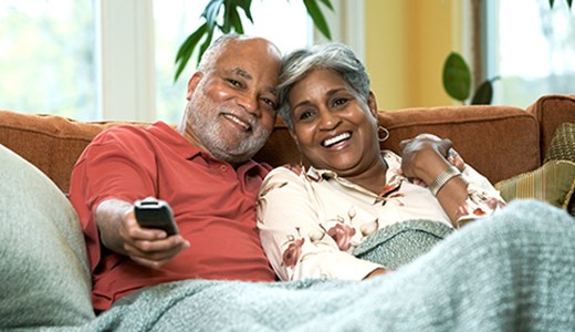 Senior couple cuddled on the couch