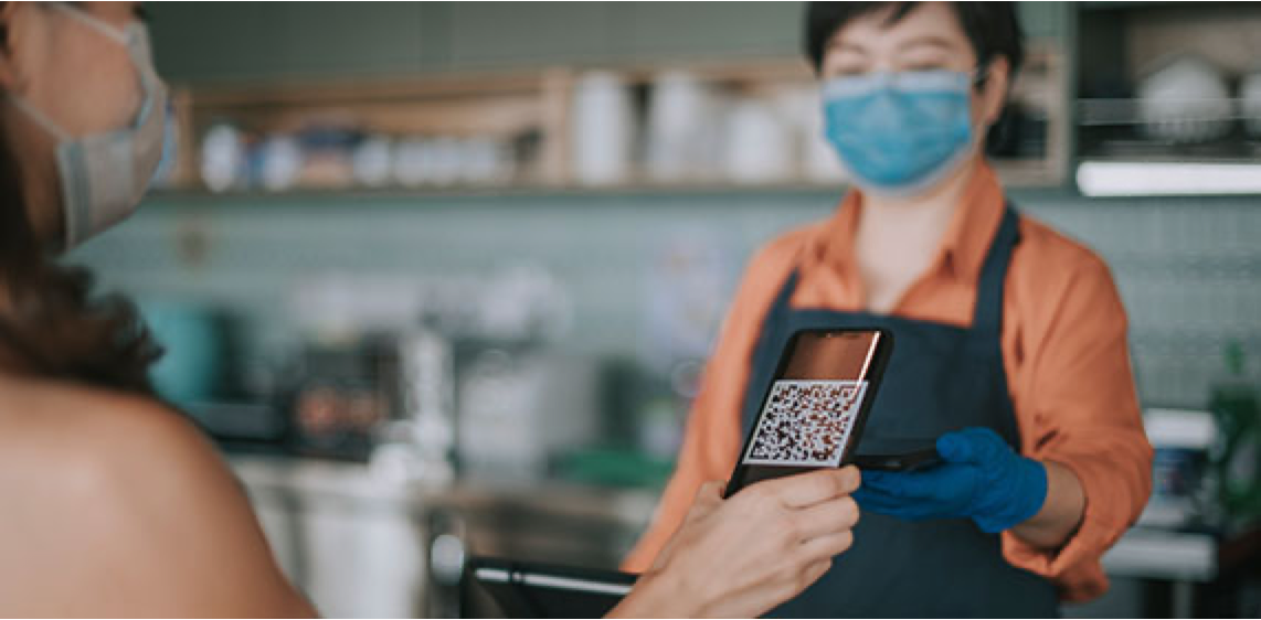 Shopper with QR code scanning for discount at local coffee shop